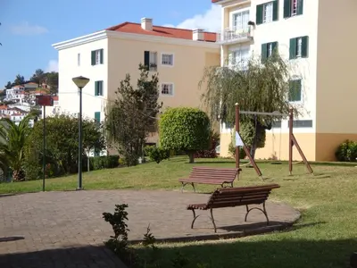 a park with two benches and a swing at Excelente T3 Duplex Funchal in Funchal