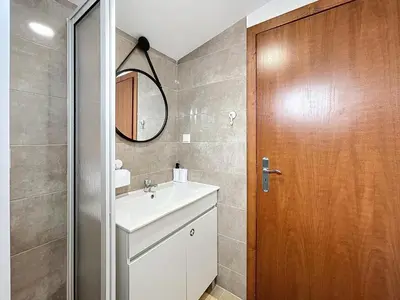 a bathroom with a sink and a wooden door at Dinos Sea View in Machico
