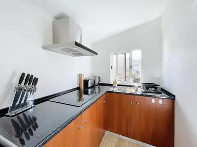 a kitchen with a counter and a sink and a window at Dinos Sea View in Machico