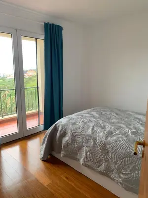 a bedroom with a bed and a large window at Ocean View Condo in Caniço
