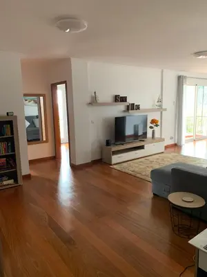 a living room with a couch and a flat screen tv at Ocean View Condo in Caniço