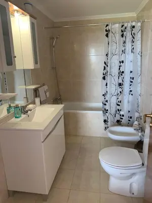 a bathroom with a toilet and a sink and a shower at Ocean View Condo in Caniço
