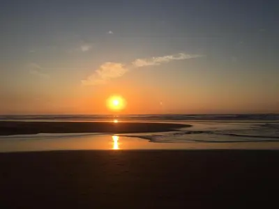 a sunset on the beach with the sun setting at Carrapateira Lodge in Carrapateira