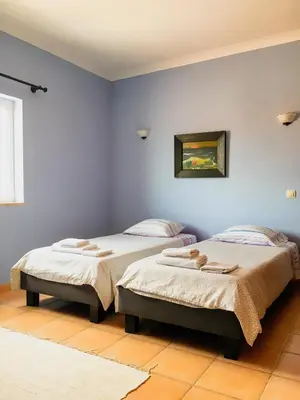 two beds in a room with blue walls at Carrapateira Lodge in Carrapateira