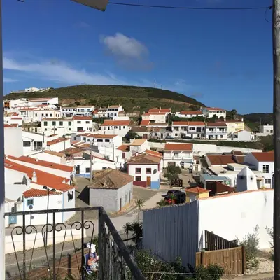 a town with white houses and a hill in the background at Carrapateira Lodge in Carrapateira