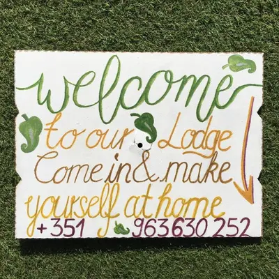a welcome sign sitting on the grass at Carrapateira Lodge in Carrapateira