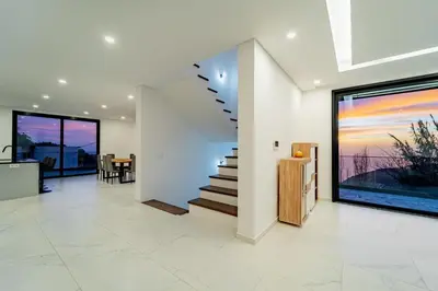 a living room with a staircase in a house at C&C Sunset Villa in Arco da Calheta