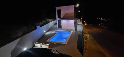 a swimming pool on top of a building at night at C&C Sunset Villa in Arco da Calheta