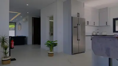 a kitchen with a refrigerator and potted plants in it at C&C Sunset Villa in Arco da Calheta
