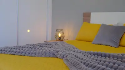 a bedroom with a large yellow bed with a lamp at C&C Sunset Villa in Arco da Calheta