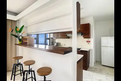 a kitchen with two bar stools and a counter at CloudyBay by Turin in Funchal