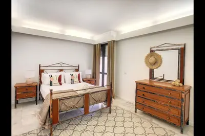 a bedroom with a bed and a dresser and a mirror at CloudyBay by Turin in Funchal