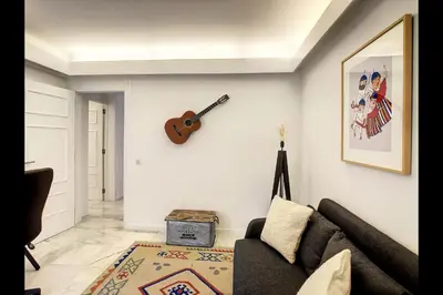 a living room with a couch and a guitar on the wall at CloudyBay by Turin in Funchal