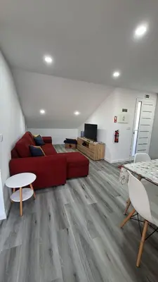 a living room with a red couch and a table at Casa Anjinho in Estreito da Calheta