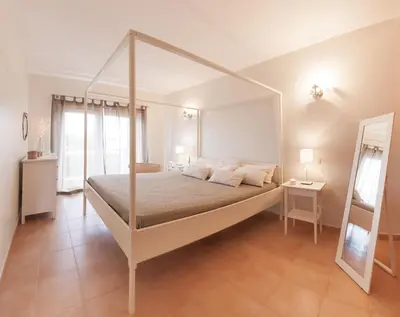 a bedroom with a canopy bed and a mirror at Apartamentos Villa T2 Vila Sagres in Sagres