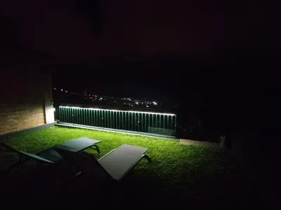 two chairs sitting on the grass at night at Capelos in Funchal