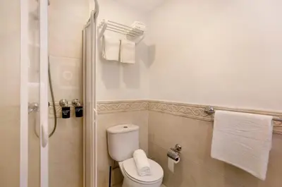 a bathroom with a toilet and a shower with towels at Capelos in Funchal