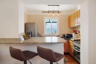 a kitchen with a counter and two chairs in it at Capelos in Funchal