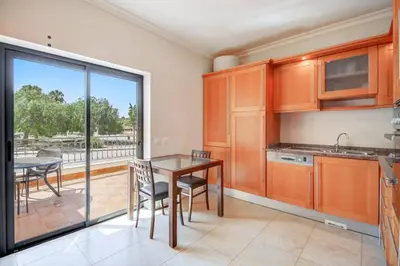 a kitchen with a table and chairs and a balcony at Casa Clara Sun, Beach and Pool in Lagos