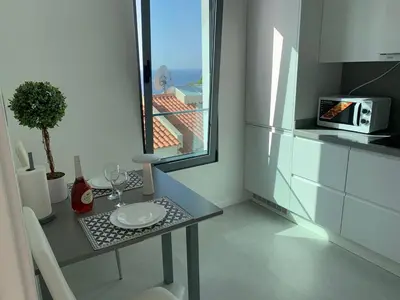 a bedroom with three beds and a table and a desk at VILLA HELENA Amber Apartment in Caniço