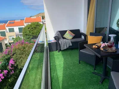 a balcony with a table with wine glasses on it at VILLA HELENA Amber Apartment in Caniço