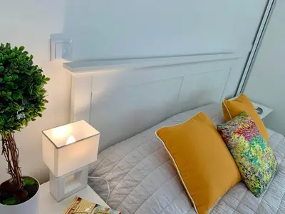 a bed with a yellow pillow and a lamp at VILLA HELENA Amber Apartment in Caniço