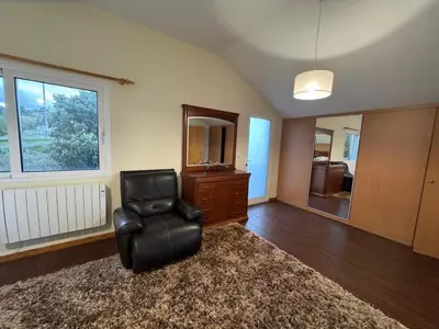 a living room with a black chair and a dresser at Prazeres Natura in Prazeres