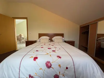 a bedroom with a large white bed with flowers on it at Prazeres Natura in Prazeres