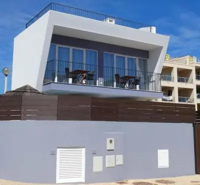 a white house with chairs on a balcony at Villa Burgau in Lagos