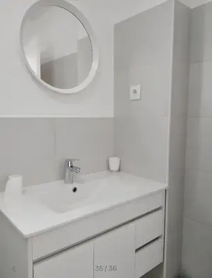 a white bathroom with a sink and a mirror at Villa Burgau in Lagos