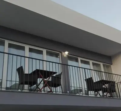 two tables and chairs on a balcony of a building at Villa Burgau in Lagos