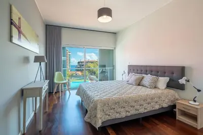 a bedroom with a bed and a sliding glass door at Luxury Villa Nogueira IV by Holiday Rental Madeira in Funchal