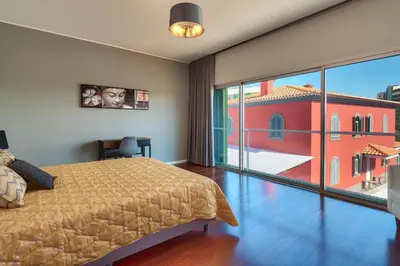 a bedroom with a bed and a large window at Luxury Villa Nogueira IV by Holiday Rental Madeira in Funchal