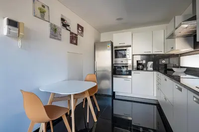 a kitchen with white cabinets and a table and chairs at Luxury Villa Nogueira IV by Holiday Rental Madeira in Funchal