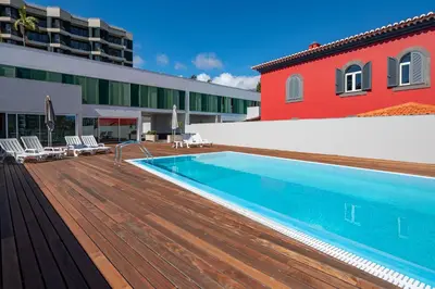 a swimming pool on a wooden deck next to a building at Luxury Villa Nogueira IV by Holiday Rental Madeira in Funchal