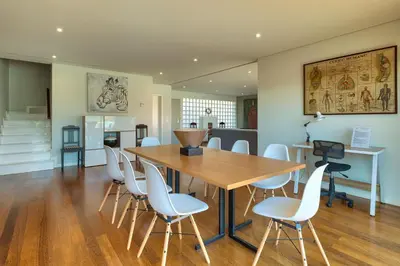 a dining room with a wooden table and white chairs at Luxury Villa Nogueira IV by Holiday Rental Madeira in Funchal