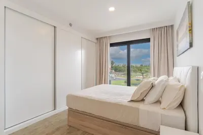 a bedroom with a bed and a large window at Orquídea Apartment by Holiday Rental Madeira in Funchal