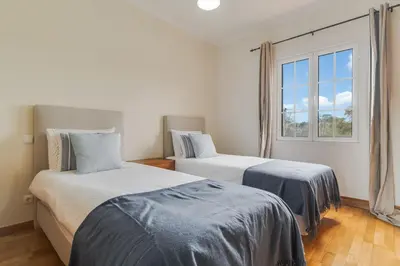 two beds in a room with a window at Porto Moniz Yellow House in Porto Moniz