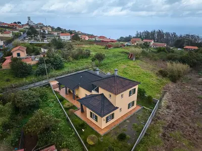 an aerial view of a house on a hill at Porto Moniz Yellow House in Porto Moniz