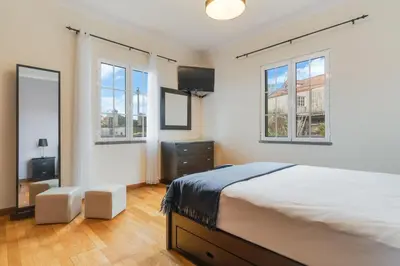 a bedroom with a bed and two windows at Porto Moniz Yellow House in Porto Moniz
