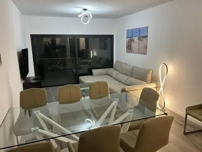 a living room with a glass table and a couch at Cliff Residence Ocean View in Gaula