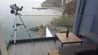 a camera on a tripod with a view of the water at Cliff Residence Ocean View in Gaula