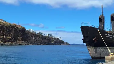 a ship docked in the water next to a cliff at Cliff Residence Ocean View in Gaula