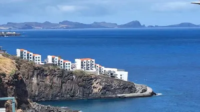 a group of buildings on a cliff next to the water at Cliff Residence Ocean View in Gaula