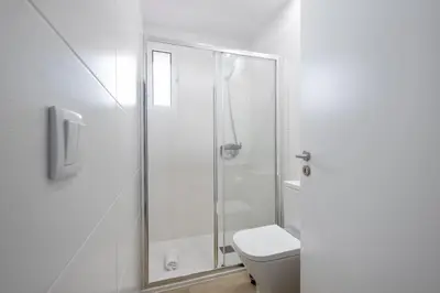 a white bathroom with a shower and a toilet at City Centre Retreat by Homie in Funchal