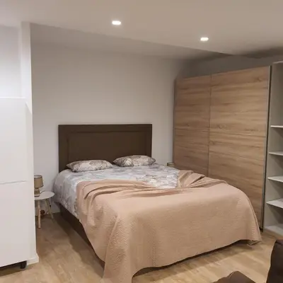 a bedroom with a large bed with a wooden headboard at Center Marina View Brown Studio in Funchal