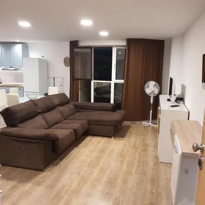 a living room with a brown couch and a kitchen at Center Marina View Brown Studio in Funchal
