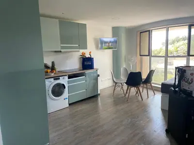 a kitchen with a washing machine and a table and chairs at Center Marina view Green Studio in Funchal