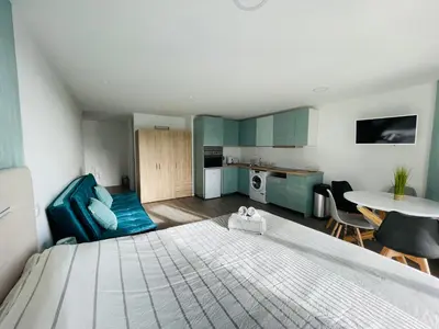 a bedroom with a bed and a kitchen and a table at Center Marina view Green Studio in Funchal