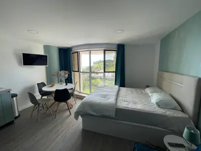 a bedroom with a bed and a table and a window at Center Marina view Green Studio in Funchal